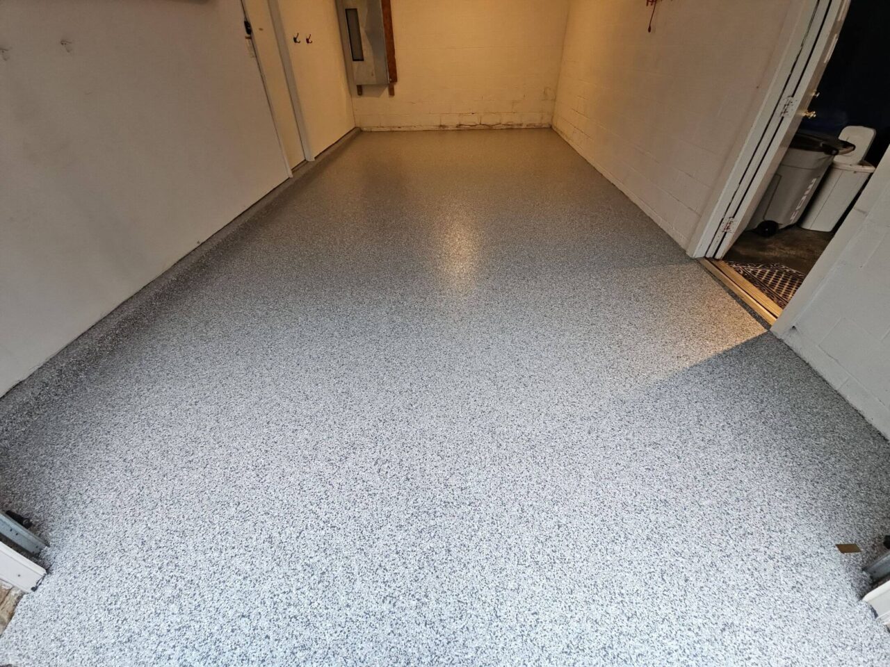 Newly coated garage floor in Tysons, featuring a light gray and white flake blend