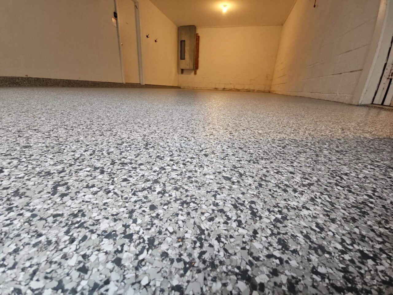 Close-up of the textured garage floor coating, showing the full flake coverage