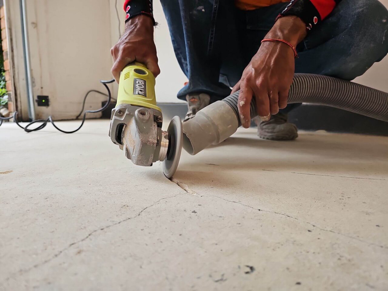 Close-up of a worker repairing cracks in the garage floor before applying the new coating