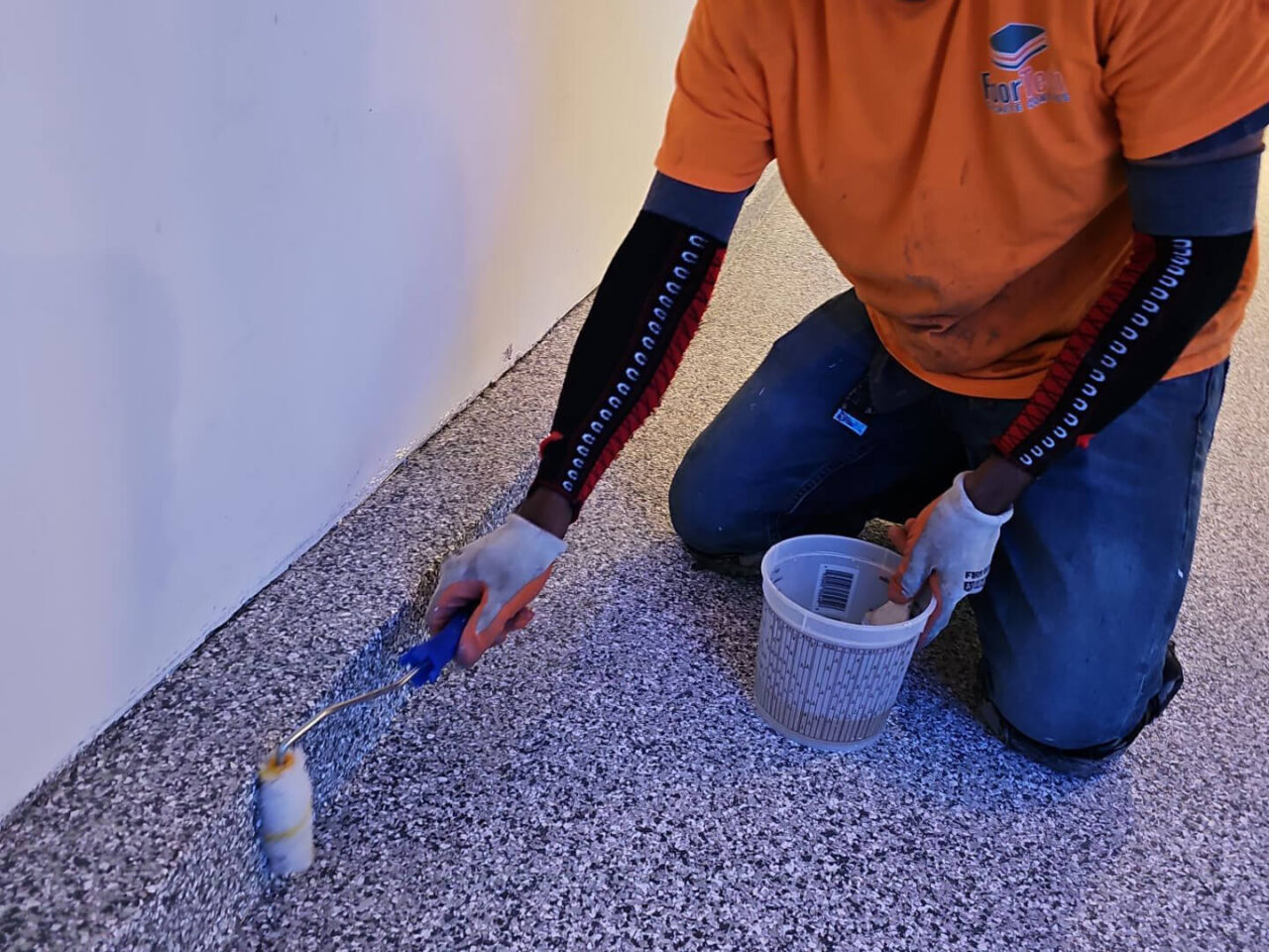 FloorTech crew member sealing the garage floor with a polyaspartic topcoat