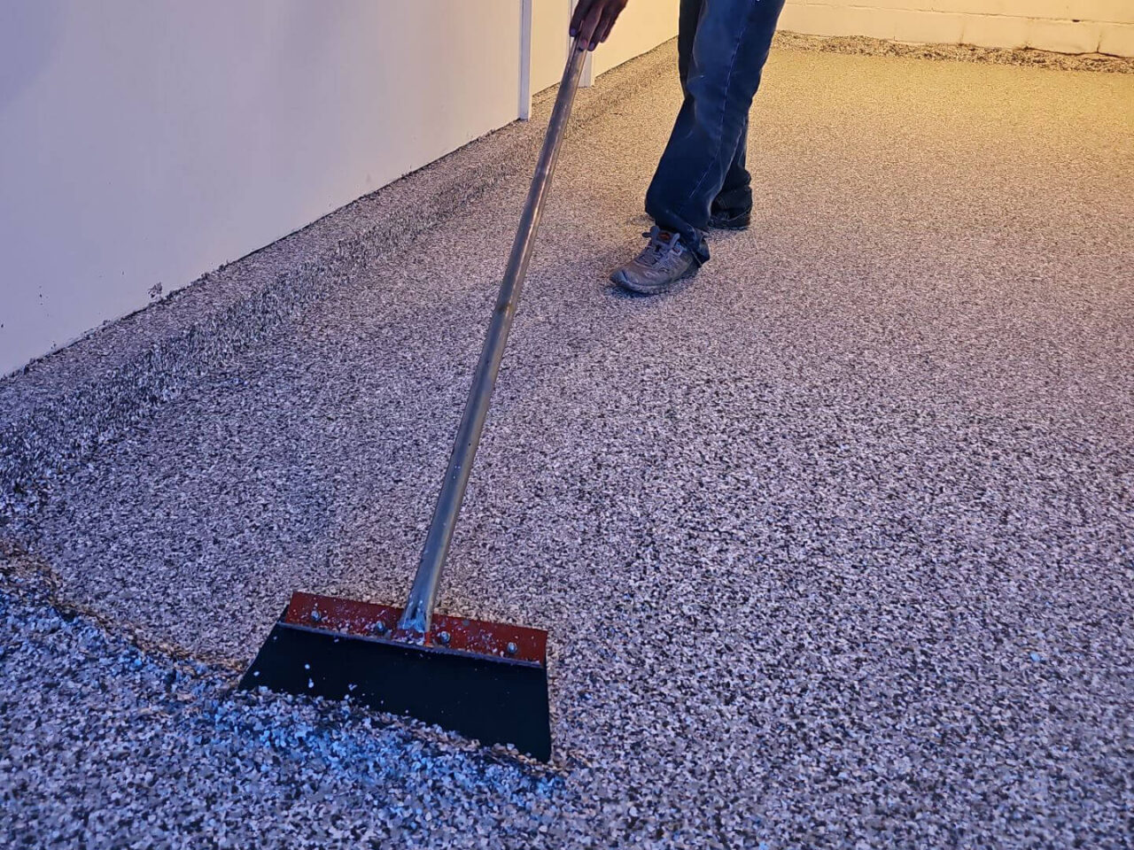 Close-up of flake being spread over the freshly coated garage floor