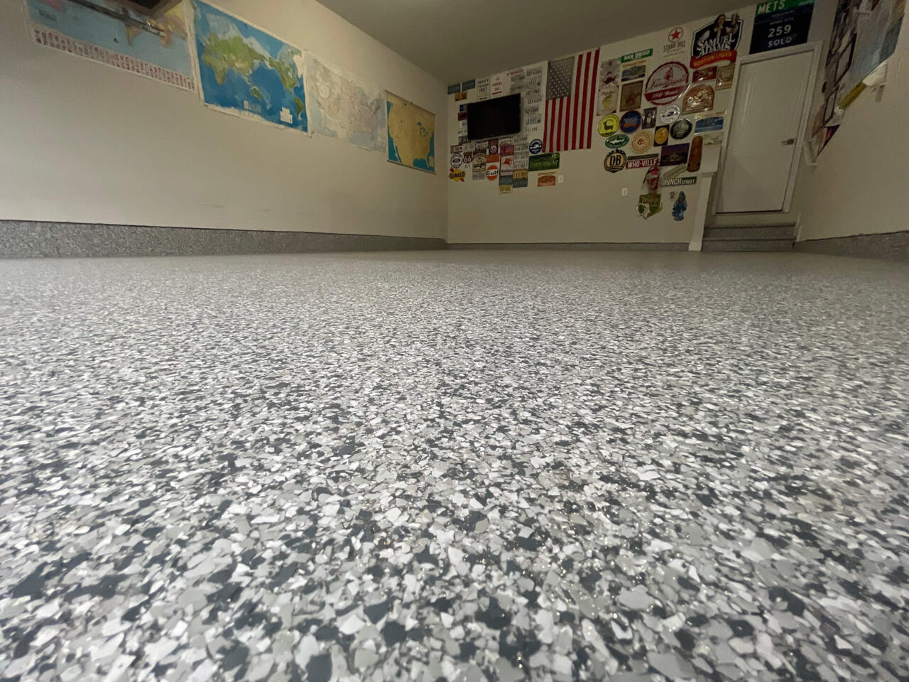 Newly coated garage floor in Gainesville with a low-angle view showing slate stone flake texture and a decorated back wall.
