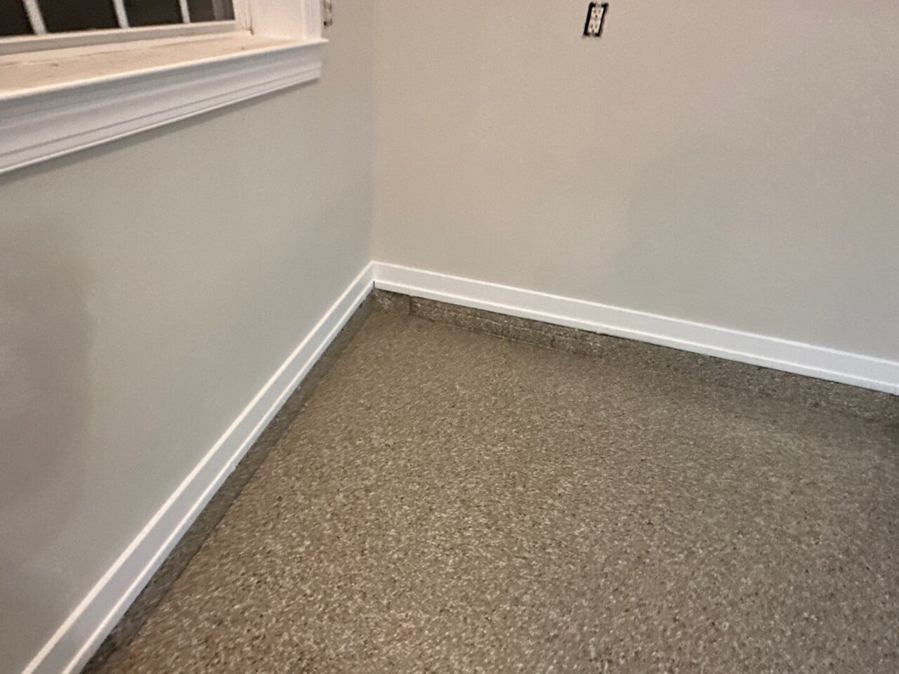 Corner of garage showing new flake coating extended slightly up the wall.