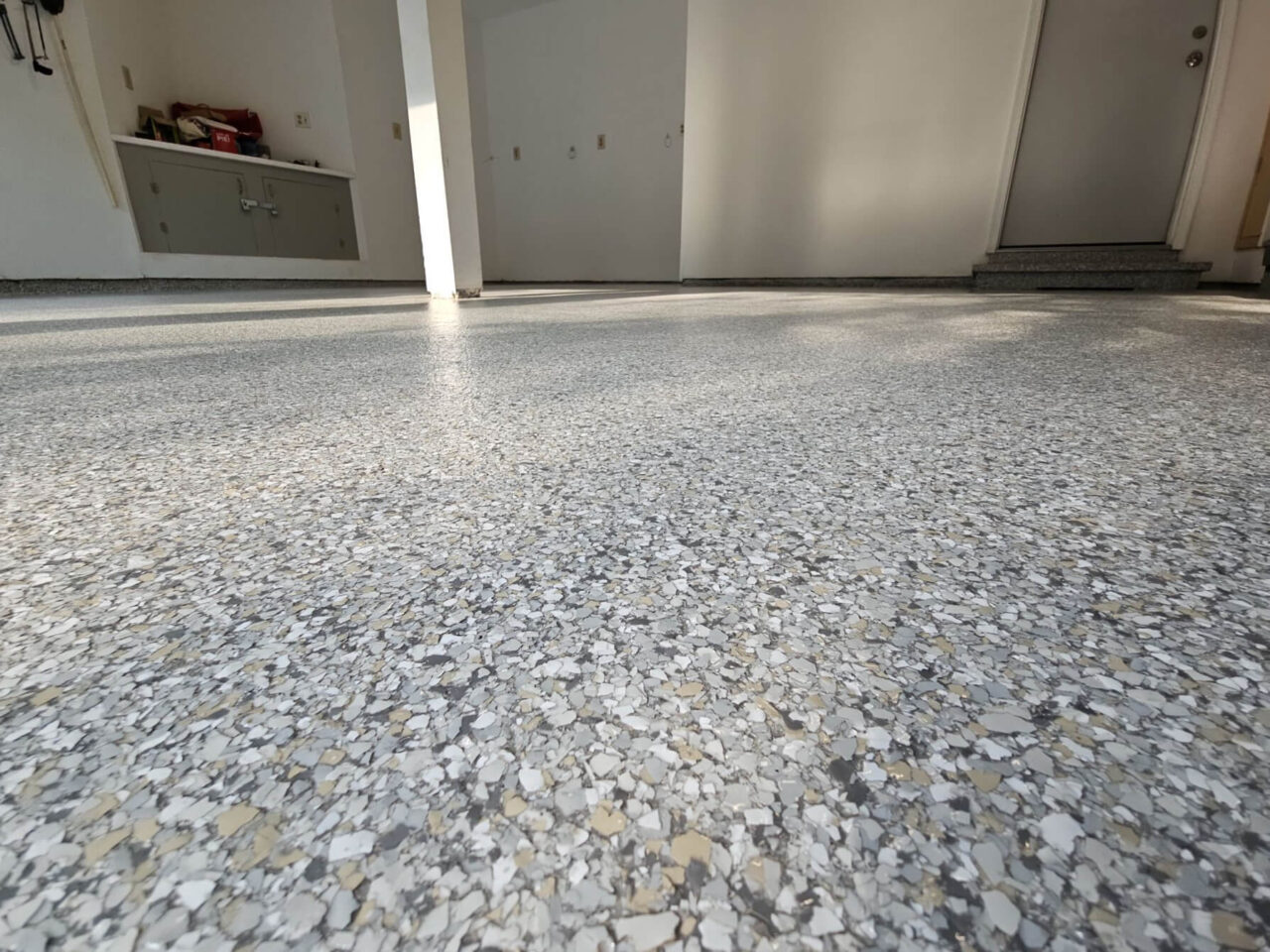 Low angle view of freshly installed Mount Everest flake garage coating with stem walls and step also coated.