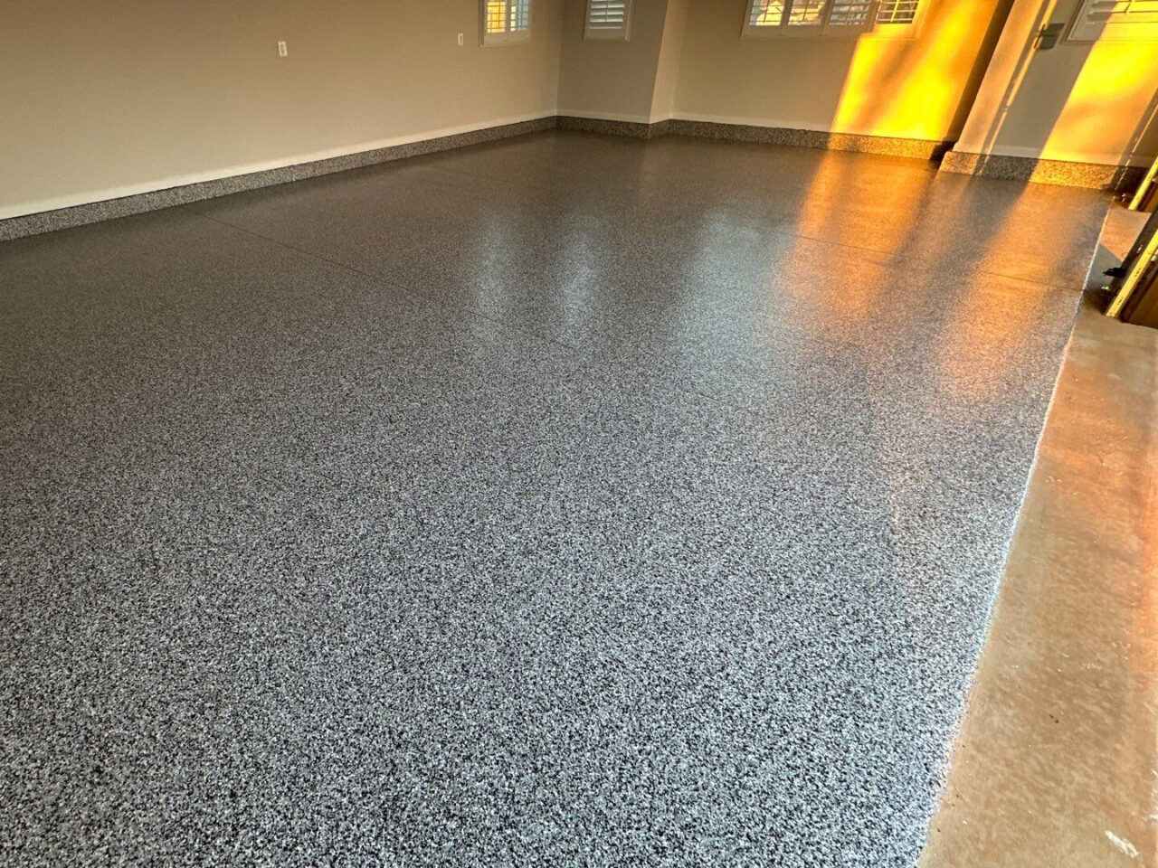 Glossy coated floor with clean edges and stem walls finished in matching flake.