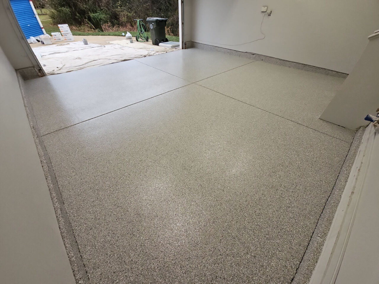 Finished garage floor with Mount Everest flake, showing even coverage and natural light reflection.