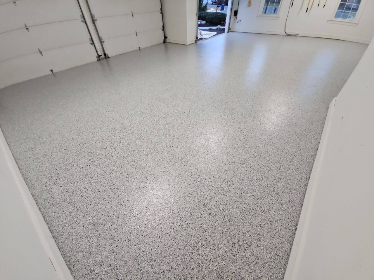 Wide view of newly coated garage with light blue and gray flake