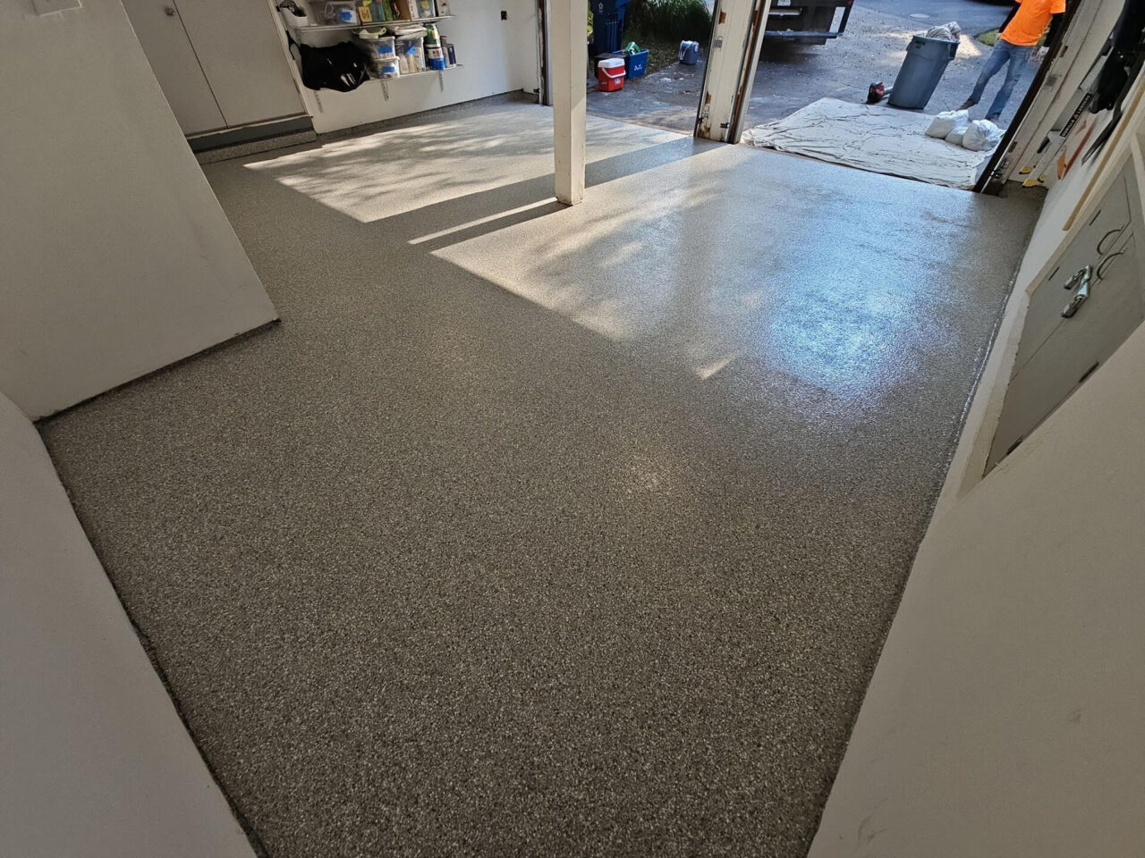Wide shot of clean garage floor after coating installation, showing even flake coverage and bright surface finish.