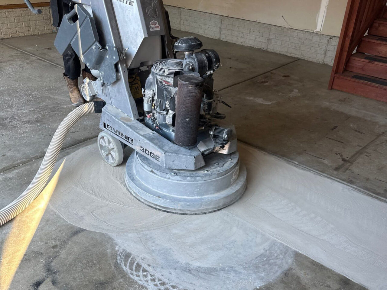 Concrete grinder in use during surface preparation stage.