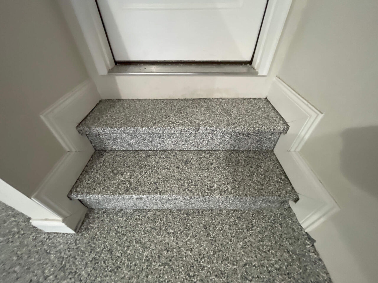 Finished garage steps coated in matching slate stone flake leading into the home.