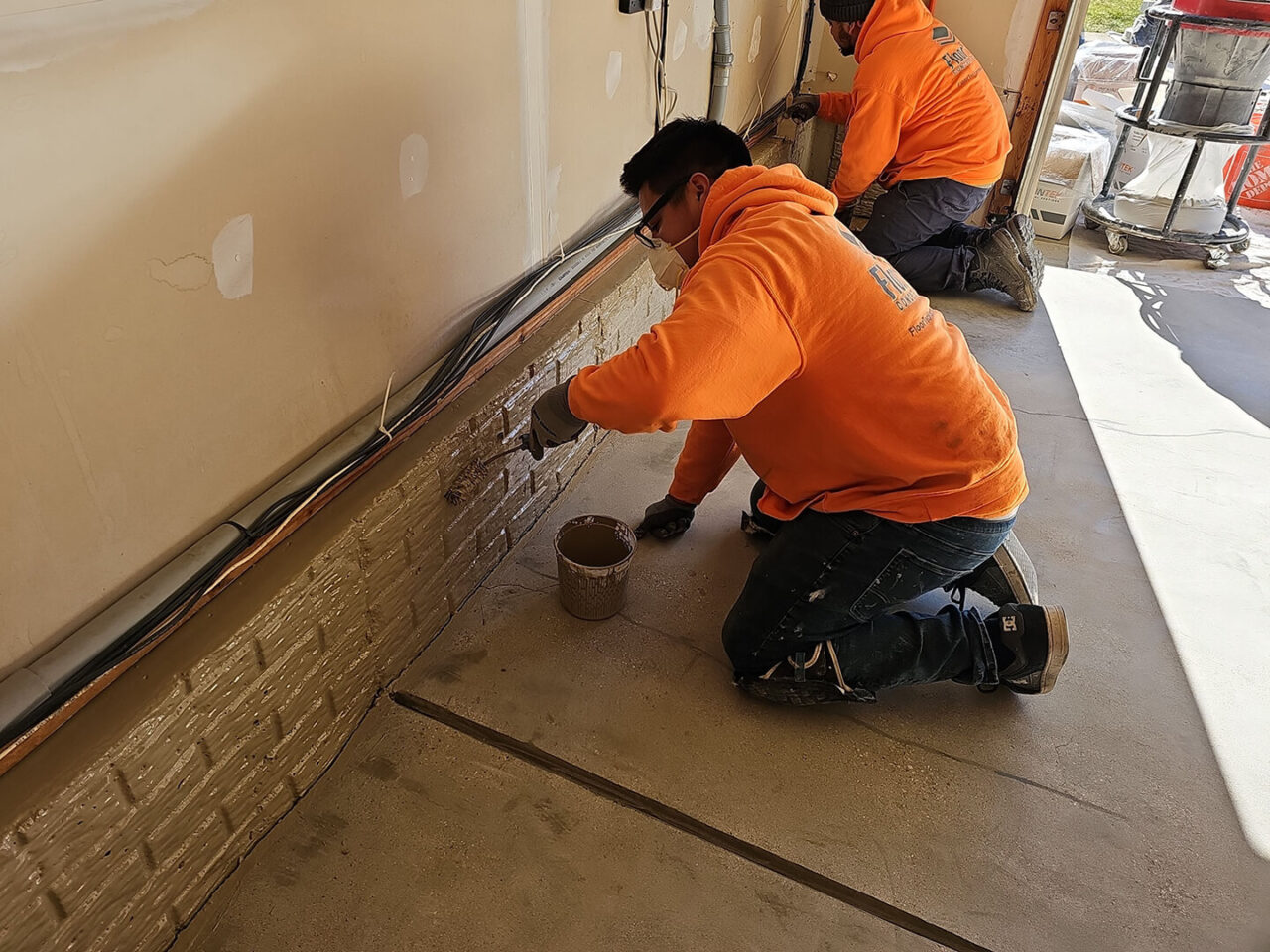 Basecoat being applied to high brick-textured stem wall.