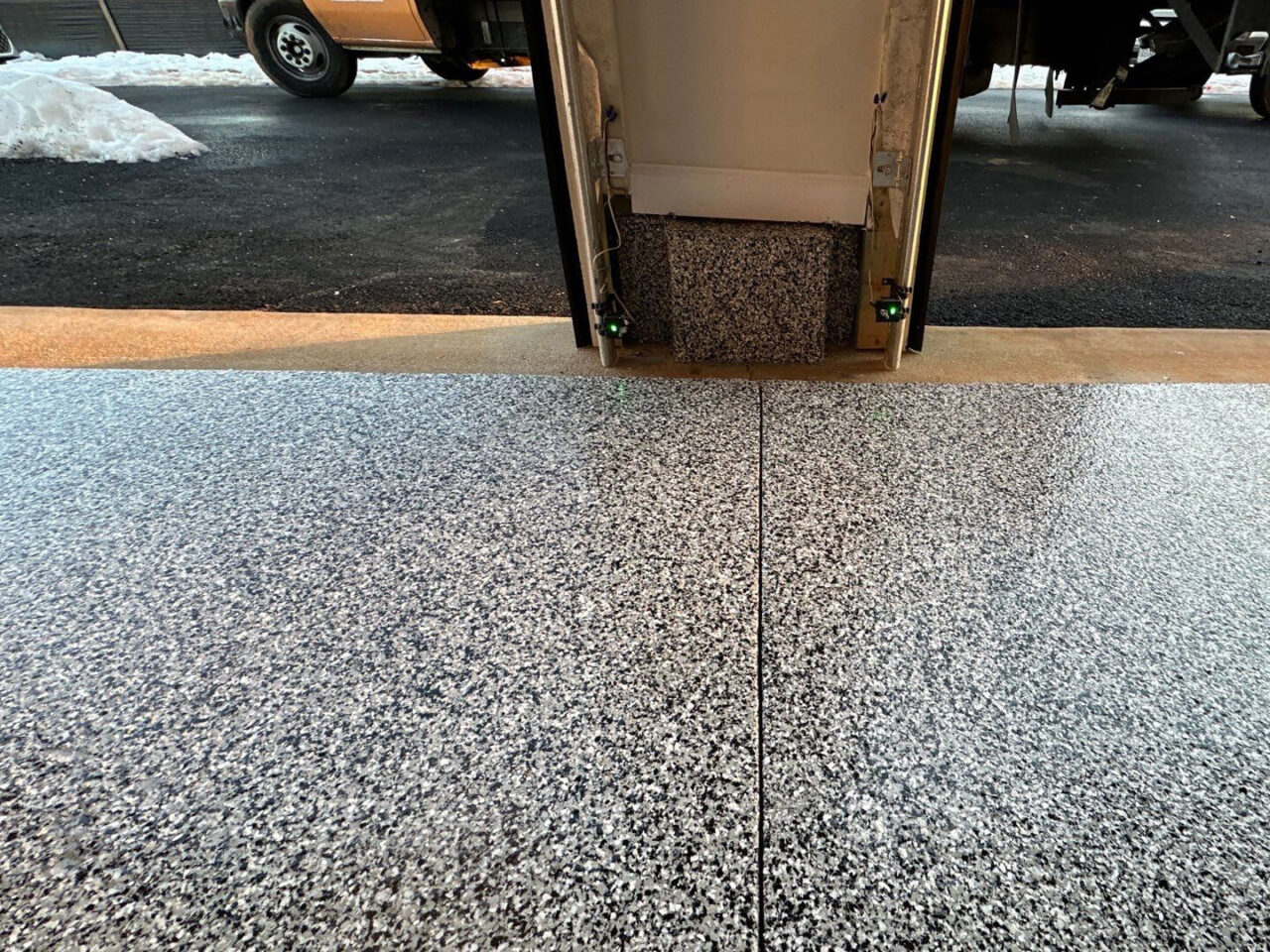 Close-up of expansion joint detail and flake texture at the garage entry.