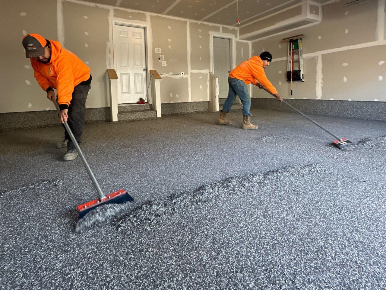 Broadcasting flake evenly across the garage floor during mid-stage of installation