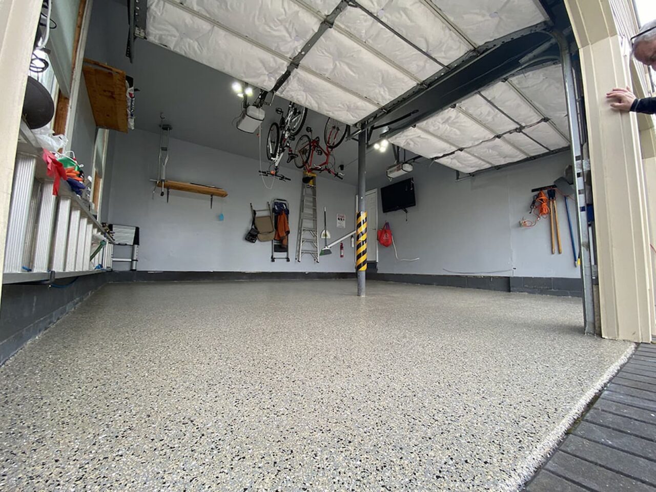Finished garage floor with a polyaspartic flake coating system designed for durability, UV stability, and long-lasting protection.